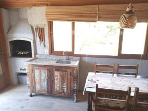 a kitchen with a sink and a table with chairs at Recanto da Natureza in Imbituba