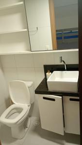 a bathroom with a white toilet and a sink at Paraíso em Tamandaré - Maui Beach in Tamandaré