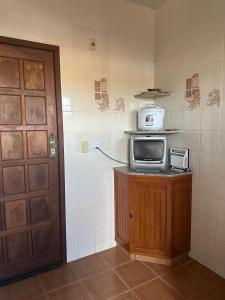 una cocina con microondas en una encimera junto a una puerta en Edifício solar de Piuma, en Piúma