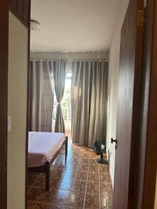 Un dormitorio con una cama frente a una ventana. en Edifício solar de Piuma, en Piúma