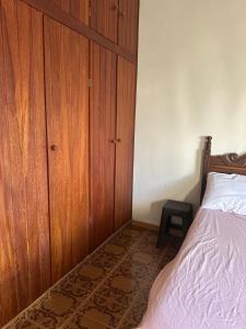 1 dormitorio con armario de madera junto a la cama en Edifício solar de Piuma, en Piúma 11 fotos más