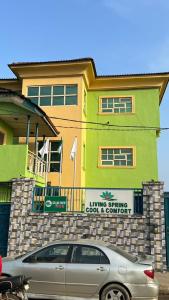 EgbaにあるLiving Spring Cool & Comfort Events and Suitesの建物の前に駐車された車