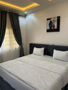 EgbaにあるLiving Spring Cool & Comfort Events and Suitesの白いシーツが敷かれた大きなベッドのある寝室