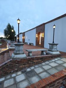 a row of benches on a brick patio with lights at Beds Inn Midrand in Midrand