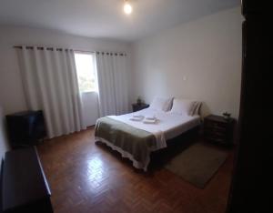 a bedroom with a white bed and a window at Casa Central in Socorro