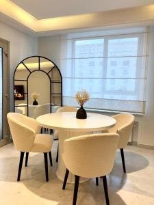a dining room with a white table and chairs at Le somptueux du lac 2 in El Aouina Station