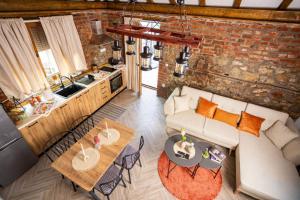 a living room with a couch and tables and a kitchen at Clock Tower Apartments Bitola in Bitola