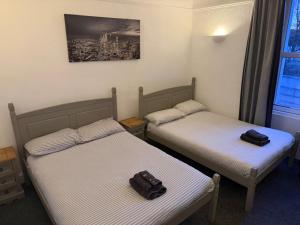 two beds in a room with a bag sitting on them at The Woodside in Cowdenbeath +9 photos