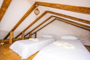 two white beds in a room with a attic at Clock Tower Apartments Bitola in Bitola