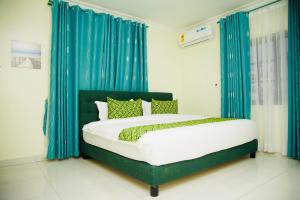 a bedroom with a bed with blue drapes at GreyCity Apartments in Accra