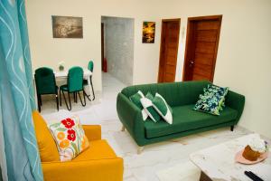 a living room with a green couch and a table at GreyCity Apartments in Accra