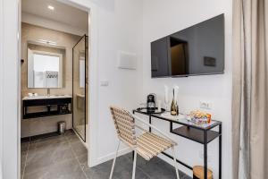 a bathroom with a table and a television on a wall at Relais San Giovanni in Rome +46 photos