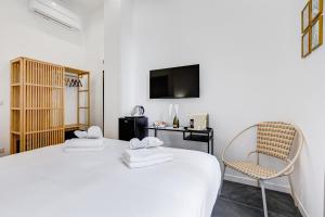 a room with a bed and a chair and a television at Relais San Giovanni in Rome