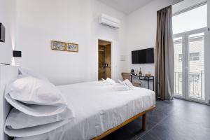 a white bedroom with a bed with white pillows at Relais San Giovanni in Rome