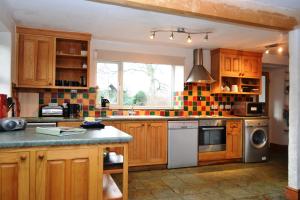 a kitchen with wooden cabinets and a stove top oven at Netherend in Threlkeld