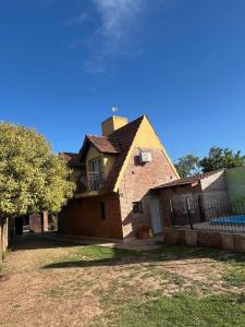 a brick house with a fence in front of it at La Alpina in Chivilcoy