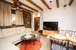 a living room with a couch and tables and a tv at Clock Tower Apartments Bitola in Bitola