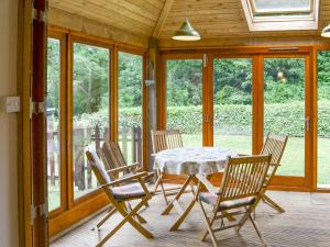 una sala da pranzo con tavolo e sedie su un portico di Elesa Cottage a Elsing