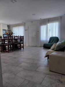 ein Wohnzimmer mit einer Couch sowie Tischen und Stühlen in der Unterkunft Coral Sur in Mar del Plata