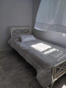 ein kleines Bett in einem Schlafzimmer, auf das das Licht scheint in der Unterkunft Coral Sur in Mar del Plata