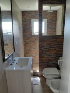 ein Badezimmer mit Waschbecken, Toilette und Spiegel in der Unterkunft Coral Sur in Mar del Plata + 10 Fotos