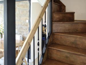 eine Holztreppe in einem Haus mit einem Tisch in der Unterkunft Trecarne Cottage in Saint Cleer + 13 Fotos