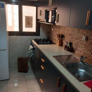 eine Küche mit Spüle und Herd in der Unterkunft Sicap baobab , Mermoz, Sacré Coeur , Clim, Wifi, Balcon, Dakar in Grand Dakar