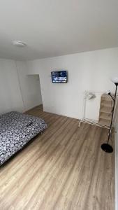a bedroom with a bed and a wooden floor at Studio F lumineux refait à neuf in Troyes