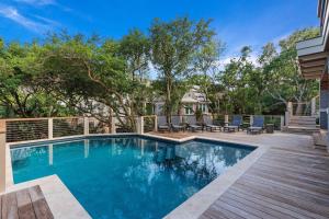a swimming pool with a deck and chairs on a house at SS59: 59 Surfsong in Kiawah Island