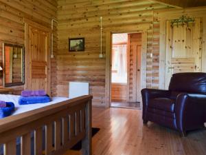 a room with a couch and a chair in a log cabin at Fingask Log Cabin - S4394 in Glenfarg