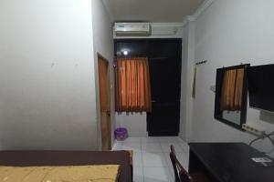 a room with a bedroom with a door and a window at JJ House Kost Exclusive Nologaten in Yogyakarta