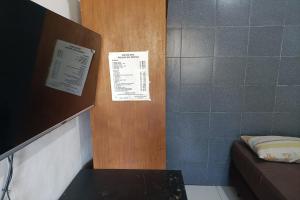 a room with a couch and two signs on a wall at JJ House Kost Exclusive Nologaten in Yogyakarta +16 photos