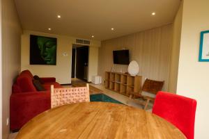 a living room with a table and a red couch at Torarica Resort in Paramaribo