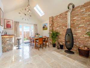 a living room with a brick wall and a wood stove at The Farmhouse in Ferndown +28 photos