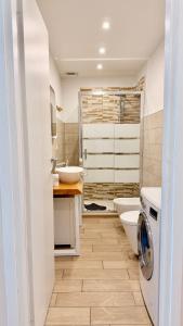 a bathroom with a sink and a washing machine at Casa Kiara by KALMA in Domodossola