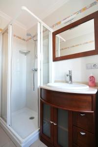 une salle de bain avec lavabo et douche dans l'établissement Apartamentos de playa en Villajuán, à Vilagarcía de Arousa 30 autres photos