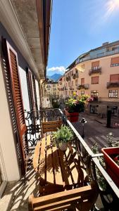 a balcony with a wooden table and benches on a building at Casa Kiara by KALMA in Domodossola