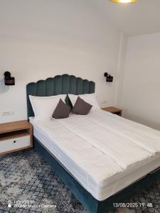 een groot bed met witte lakens en bruine kussens bij Emirage Pool & Spa in Şimon +23 foto's