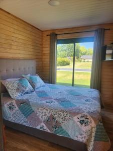 a bedroom with a bed and a large window at Cabaña independiente Quillón in Chillancito +15 photos