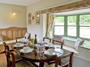 a dining room with a table and chairs and a window at West End Farmhouse in Barmston