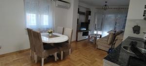 a kitchen and living room with a white table and chairs at Apartman Ciric in Vrnjci