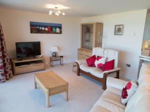 een woonkamer met een bank en een tv bij Apartment 5 Latitude 51 Westward Ho! in Westward Ho