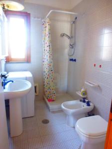 La salle de bains est pourvue d'un lavabo, de toilettes et d'une douche. dans l'établissement LGVacanze 8 posti letto, à Sibari