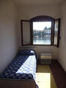 um pequeno quarto com uma cama e uma janela em LGVacanze 8 posti letto em Sibari