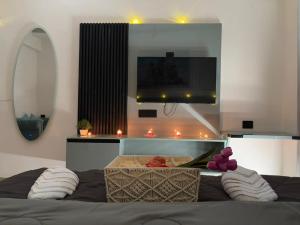 a bedroom with a tv and a bed with pillows at Kremlin Luxury Studios in Ghaziabad +8 photos