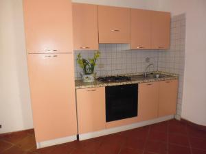 cocina con armarios de color naranja y fregadero en LGVacanze 8 posti letto, en Sibari