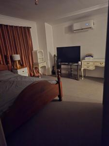 a bedroom with a bed and a flat screen tv at Odira Demi-Apartment in Baldivis