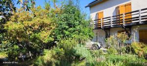 a building with a tree in front of it at Etage Bleu à la montagne in Saint-Julien-en-Champsaur