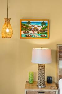 eine Lampe auf einem Tisch mit einem Gemälde an der Wand in der Unterkunft The Sea Spray at Cottages in Sand Bluff