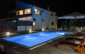 a large swimming pool in front of a house at night at Beautiful Apartment In Sukosan in Donje Raštane +32 photos